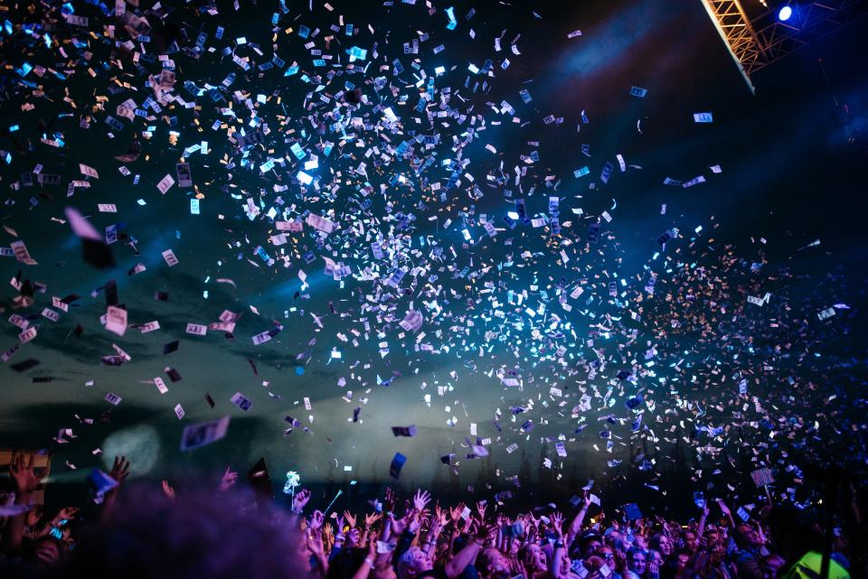 A festival main stage mid-set — crowd, lights, and confetti
